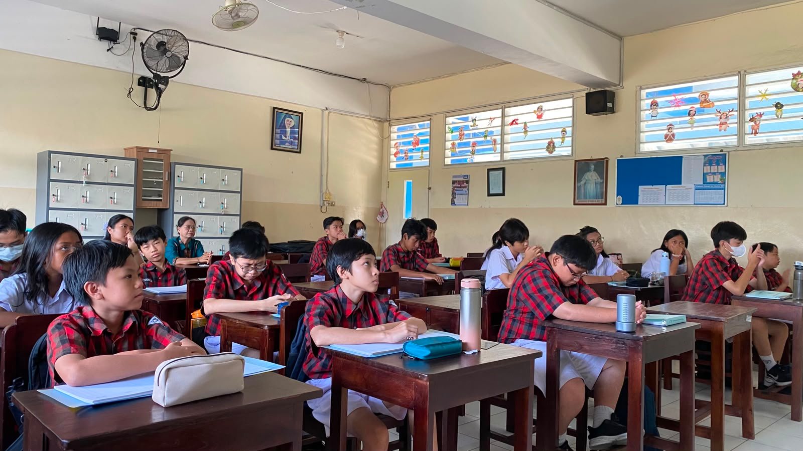 Siswa dan Siswi bersama dengan Guru sedang melaksanakan doa Novena Yubile 75 Tahun Yayasan Tarakanita di ruang kelas masing - masing